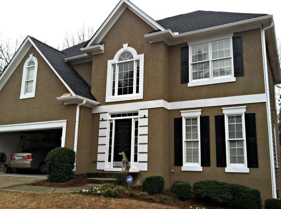 A brown house with white trim and black shutters
