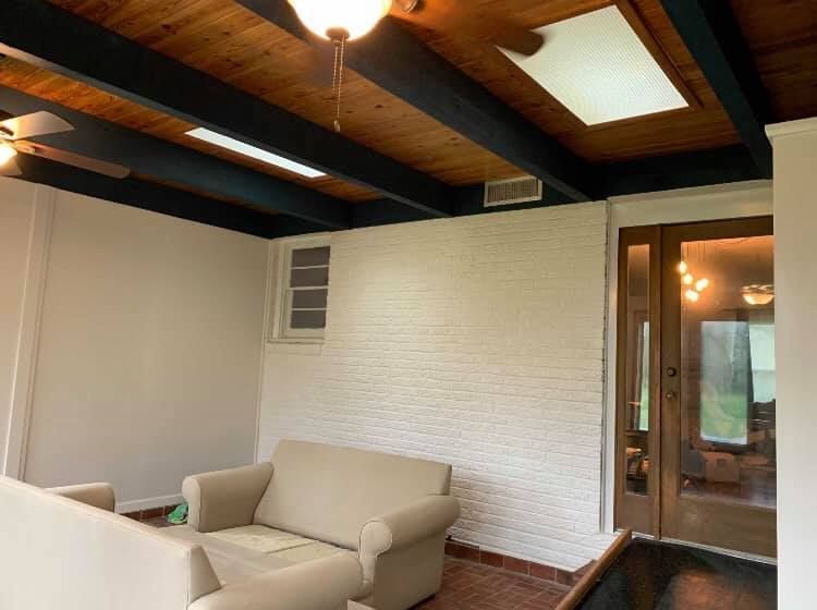 A living room with a couch and chair and a ceiling fan