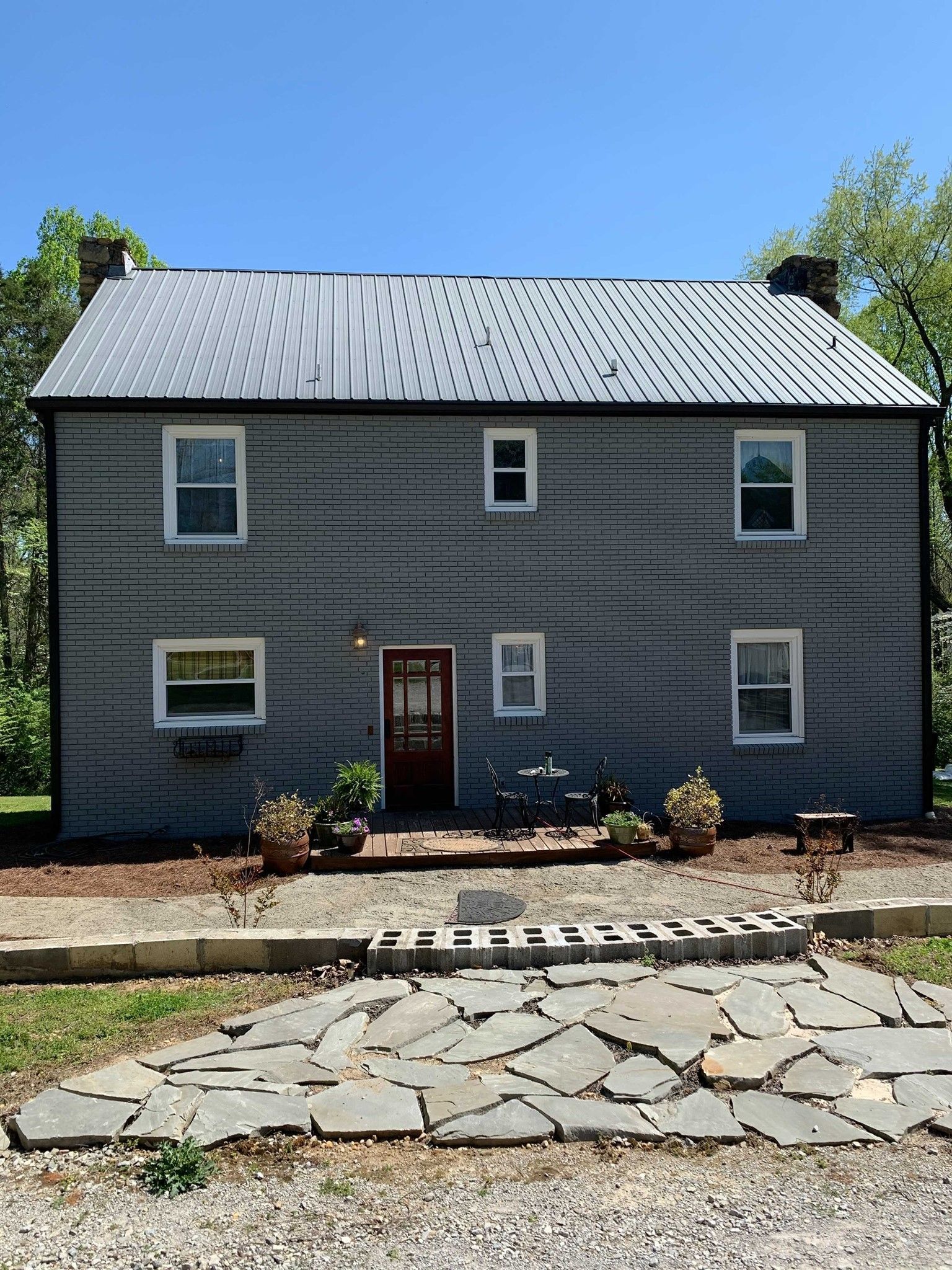 A large gray house with a metal roof