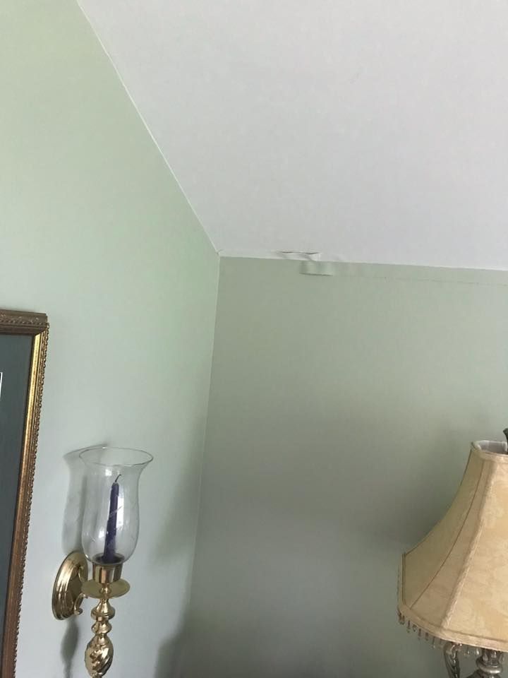 A lamp is hanging on a wall next to a candle holder.