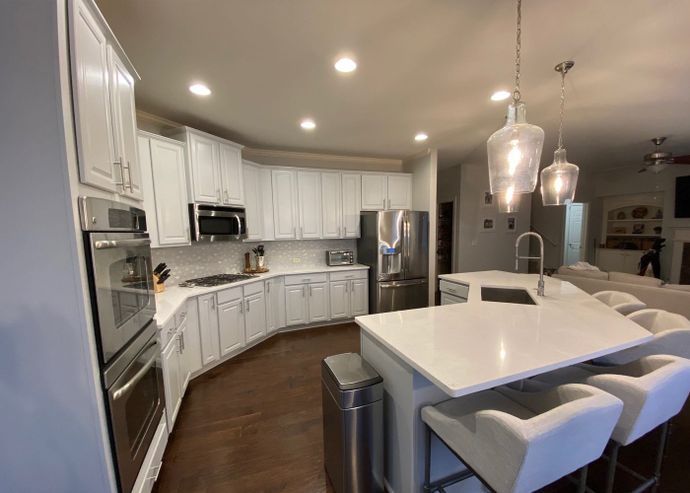 A kitchen with white cabinets and stainless steel appliances