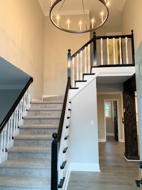 A staircase with a chandelier hanging from the ceiling