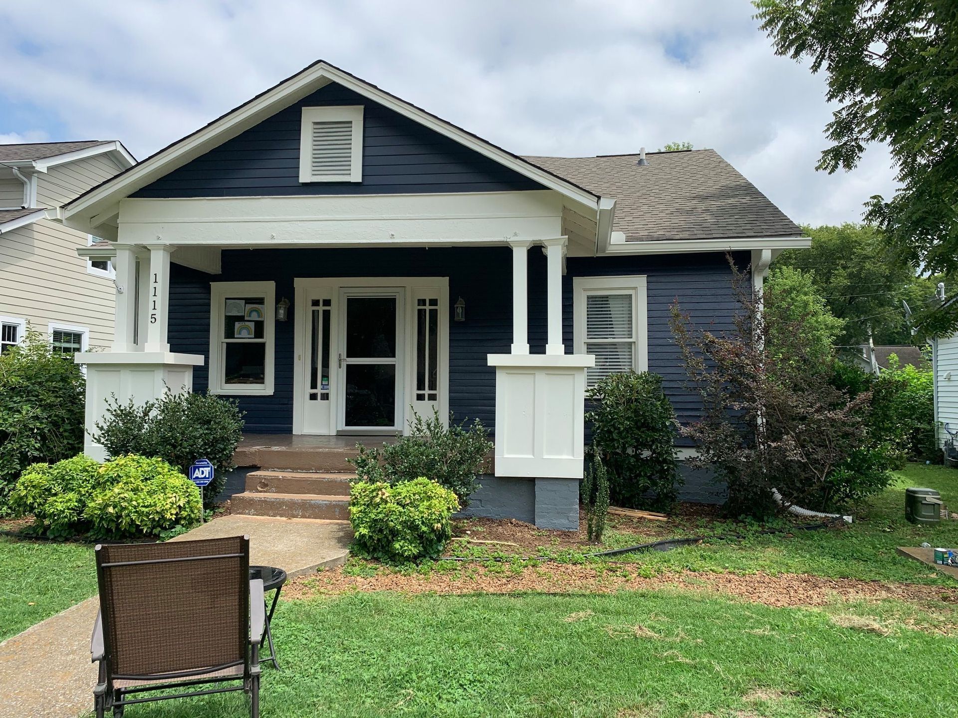 A blue and white house with a chair in front of it