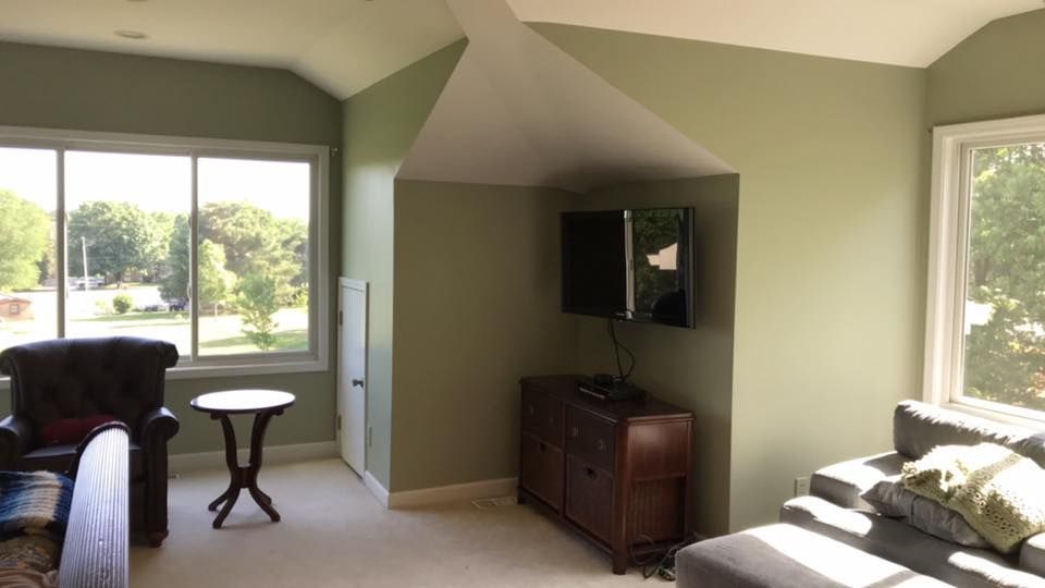 A living room with a couch , chair , table and television.