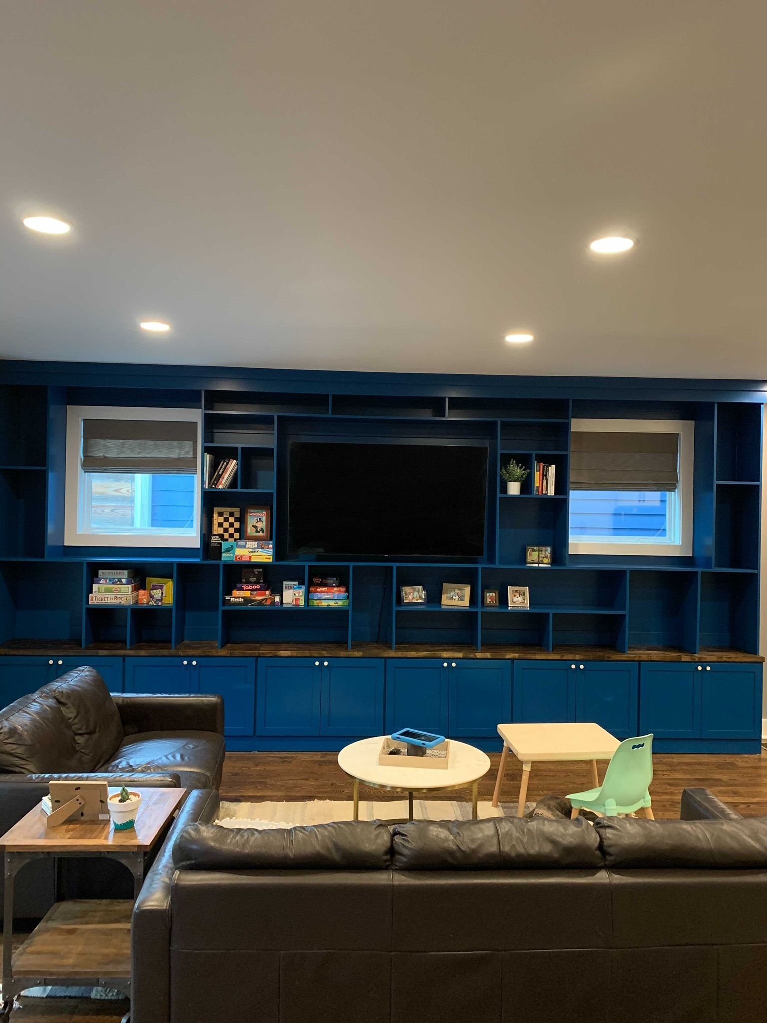 A living room with blue cabinets and a flat screen tv