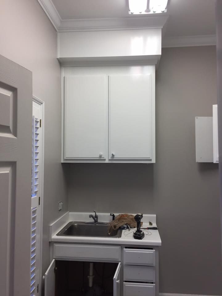A small kitchen with white cabinets and a sink.