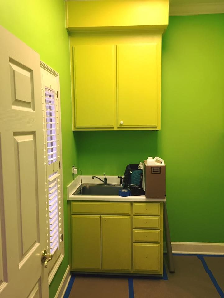 A kitchen with green walls and yellow cabinets