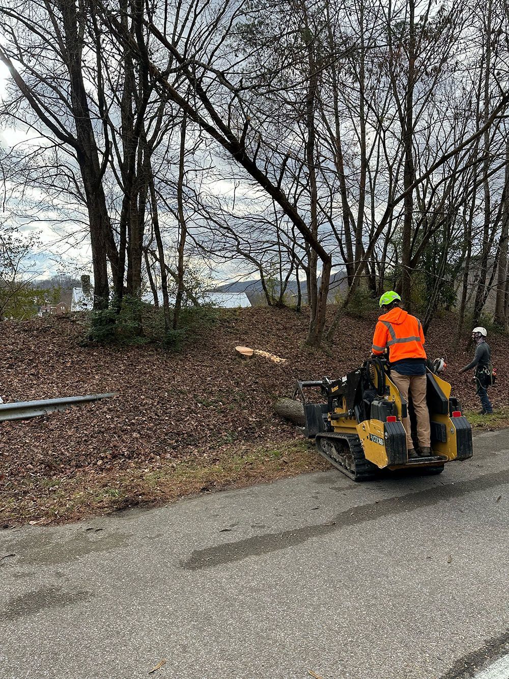 A worker using a backhoe to fix a road.
