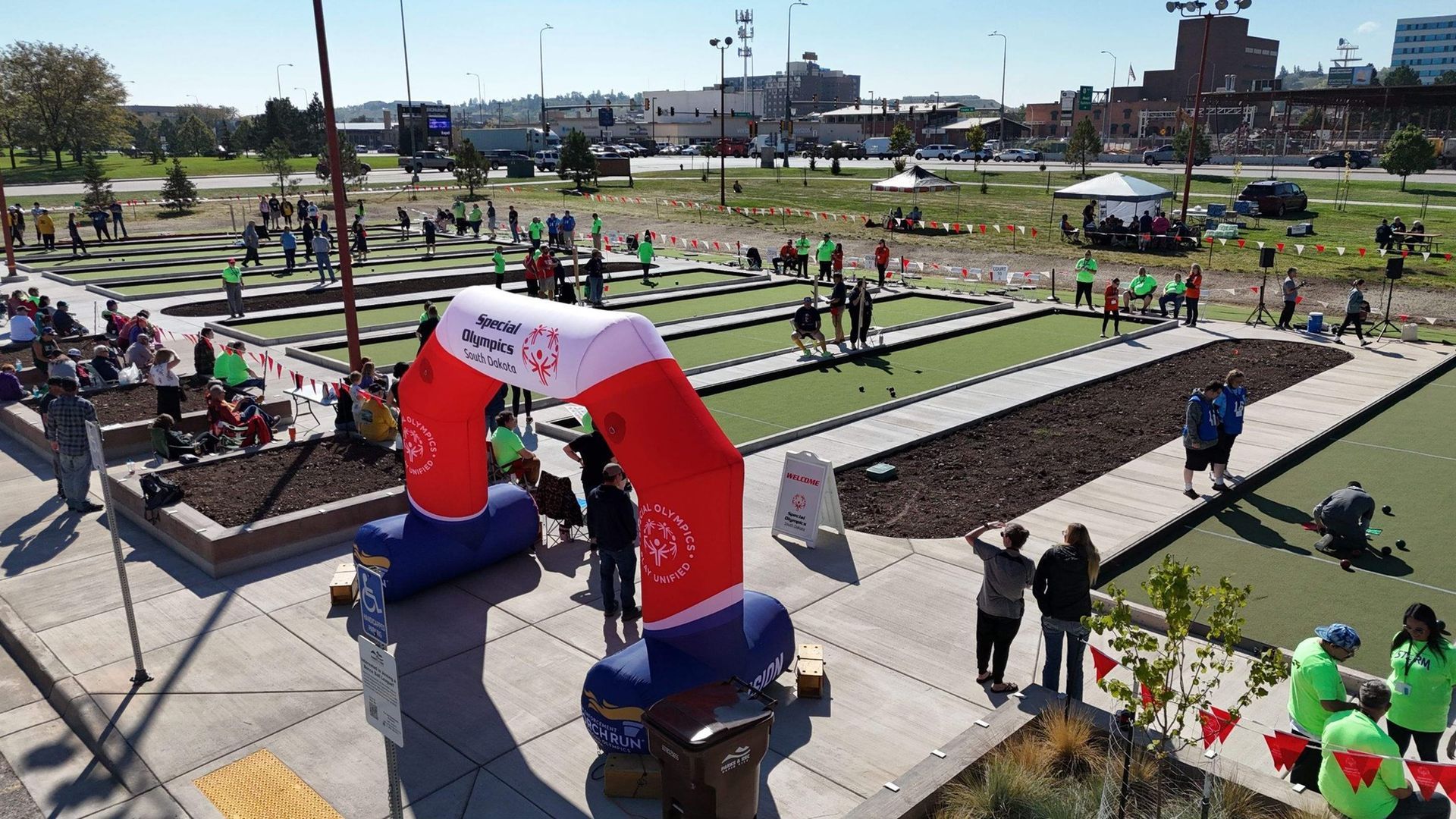 Outdoor bocce ball tournament; players aiming, throwing balls