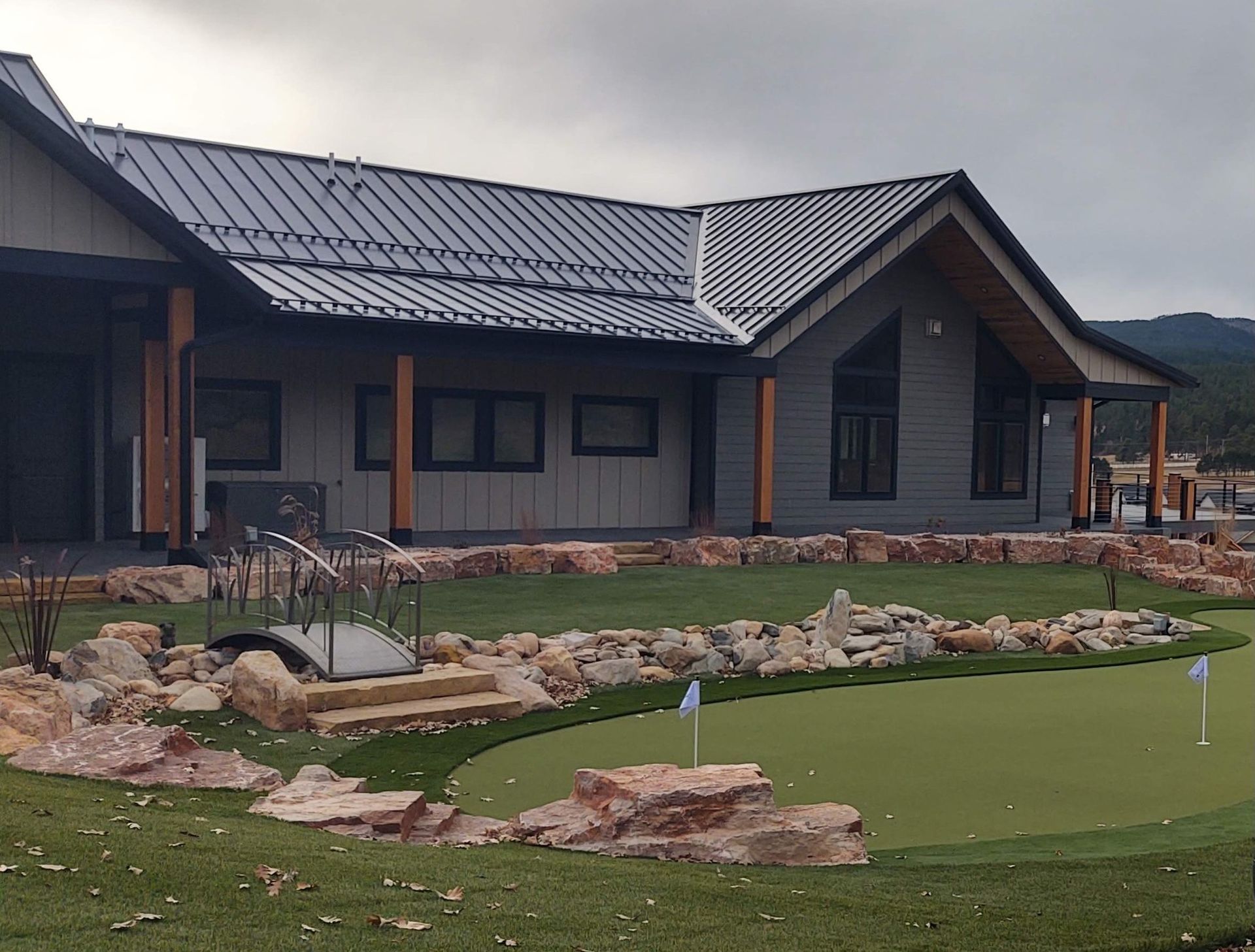 Building with a putting green and decorative rocks