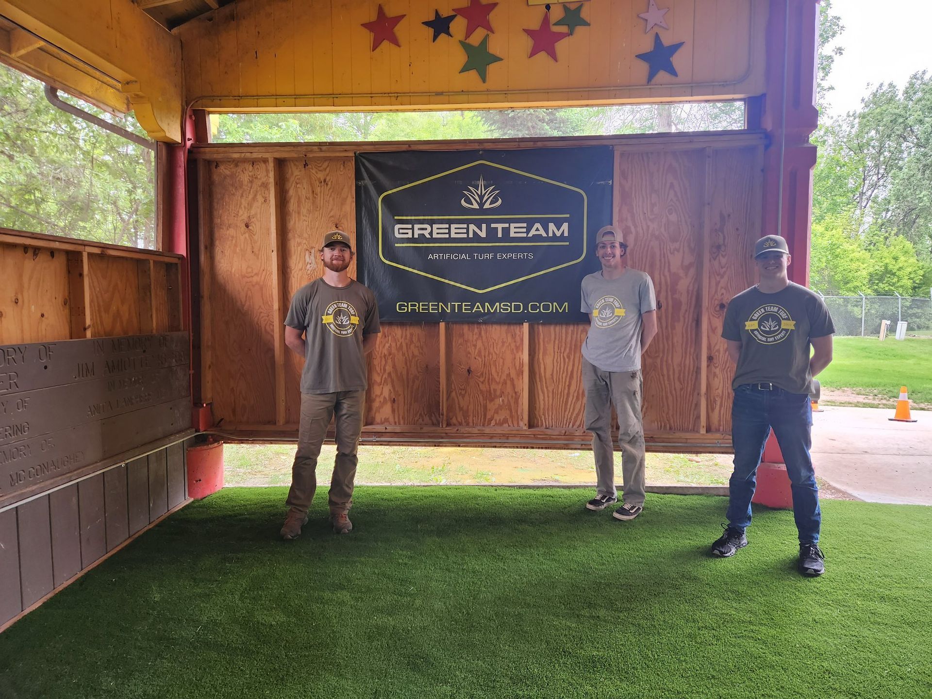 Three people stand in front of a banner labeled 