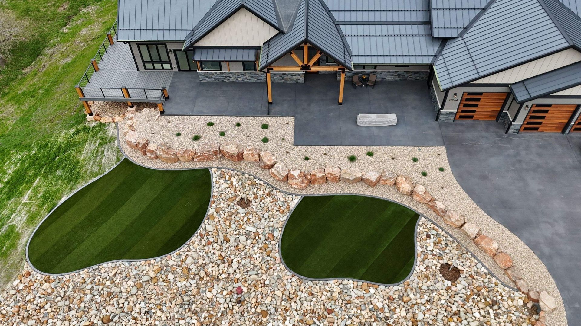 Aerial view of a modern house with a stone and grass landscape