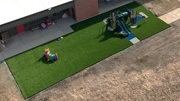 Playground with green turf, slides, and tunnel