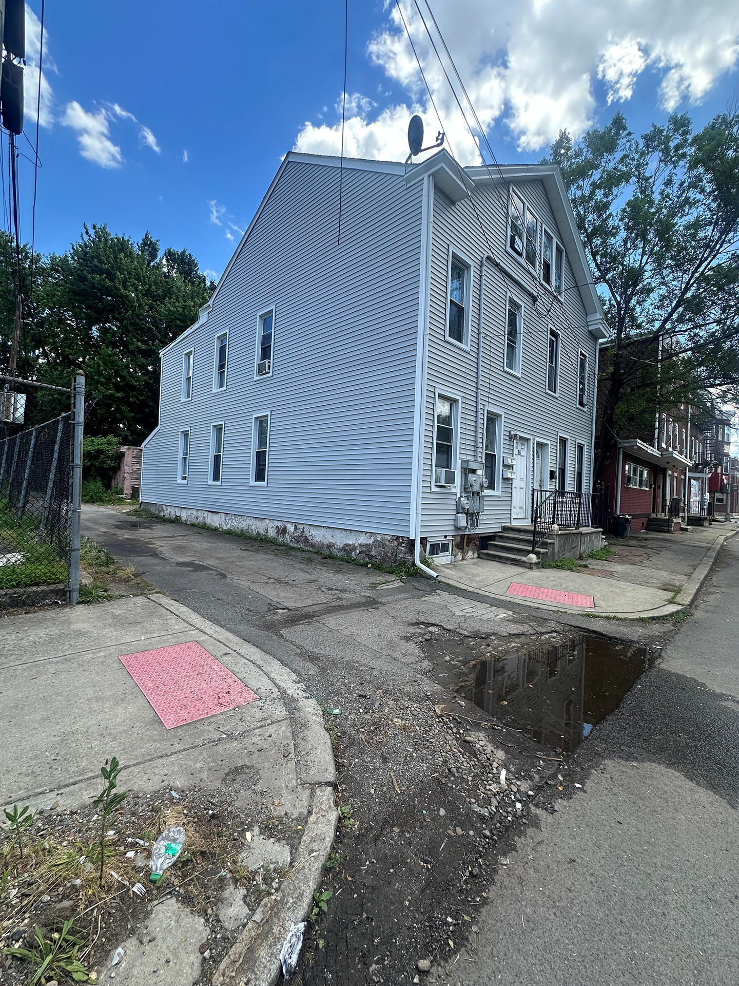 A large white building is sitting on the corner of a street