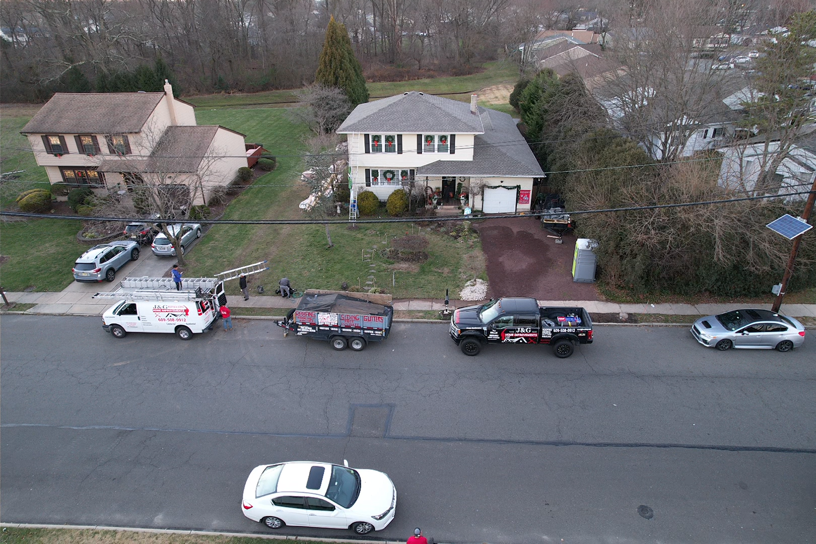 An aerial view of a house with a lot of cars parked in front of it