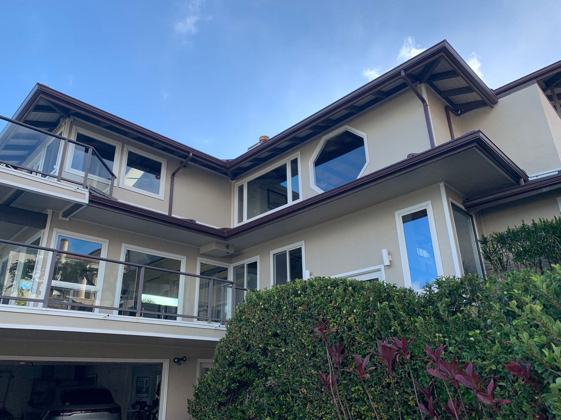 House with a balcony and a hedge