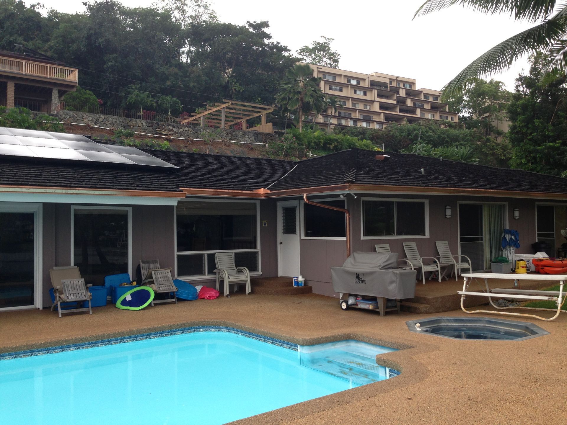 House with a pool and a building in the background