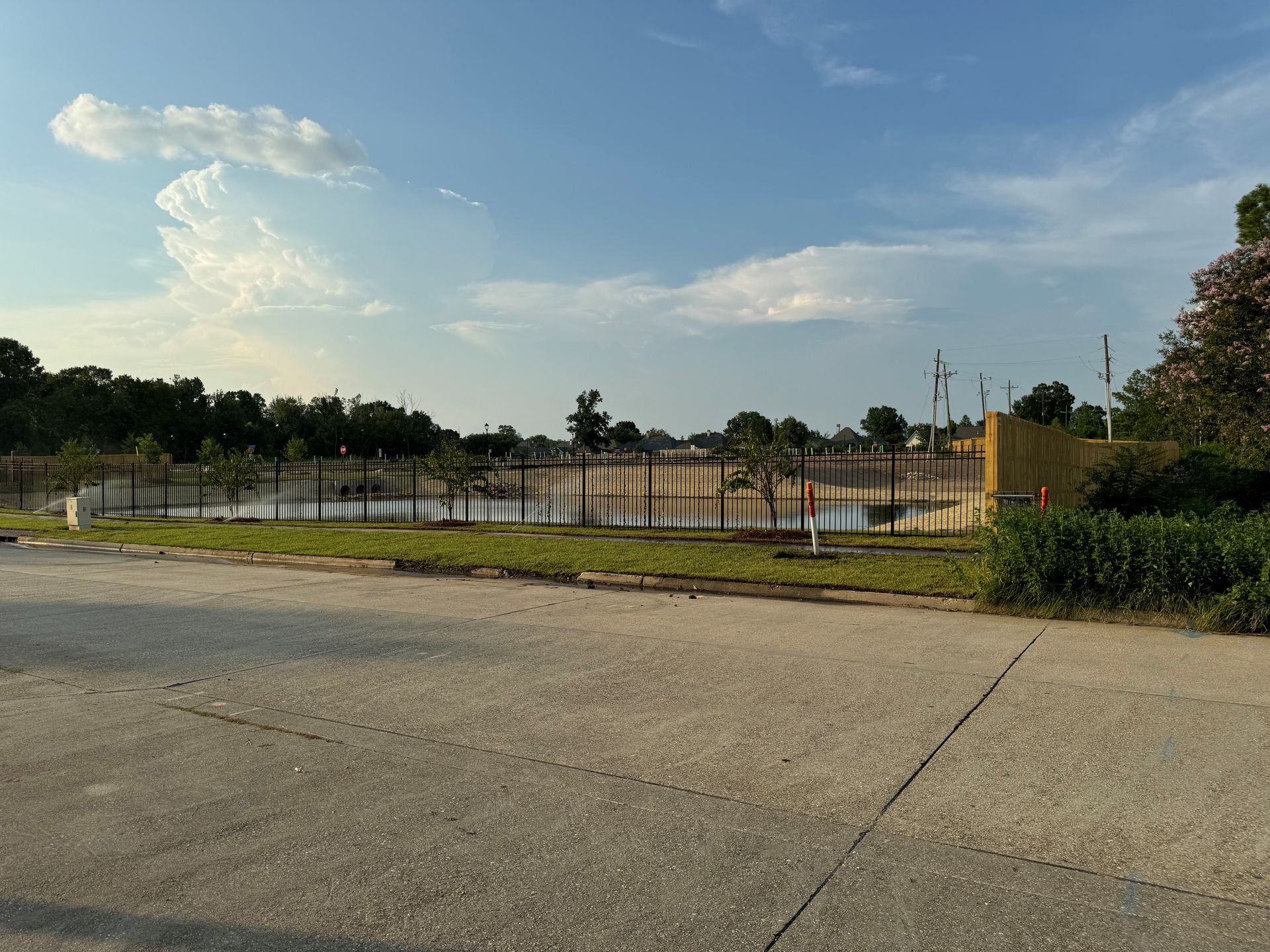 A fenced in area with a lake in the background