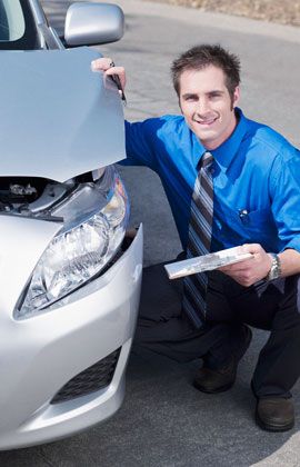 Inspector checking on a damaged car