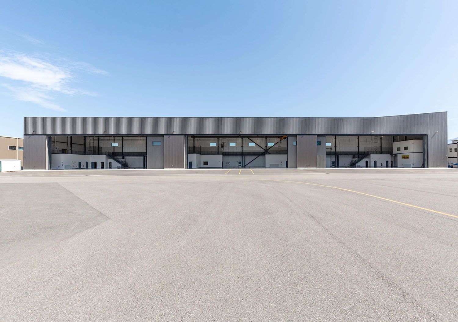 A long, low industrial warehouse with a textured grey facade
