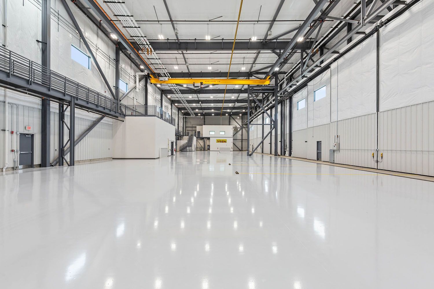 A vast, empty industrial warehouse with high ceilings