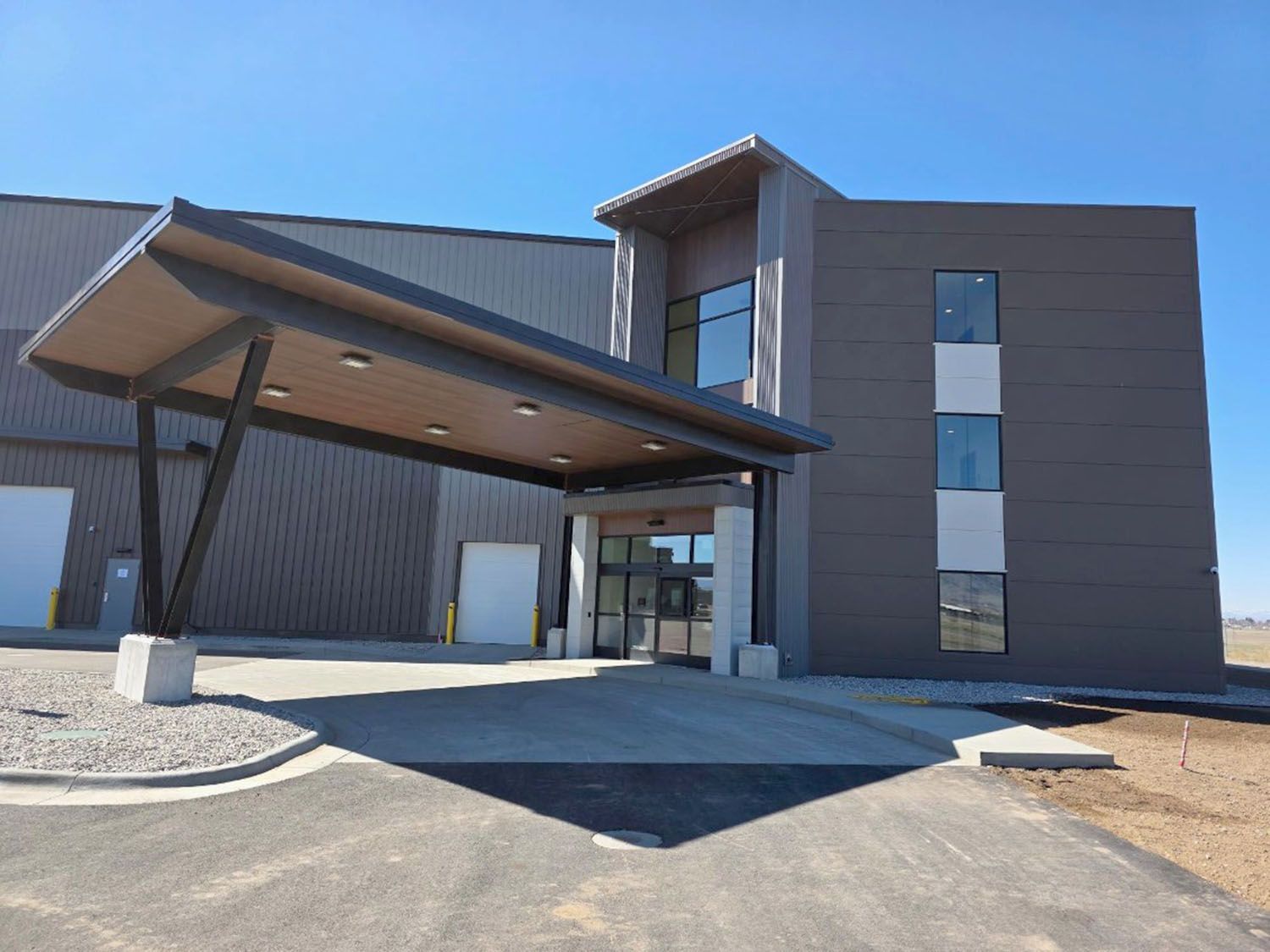 Modern industrial building exterior with a dark grey metal facade