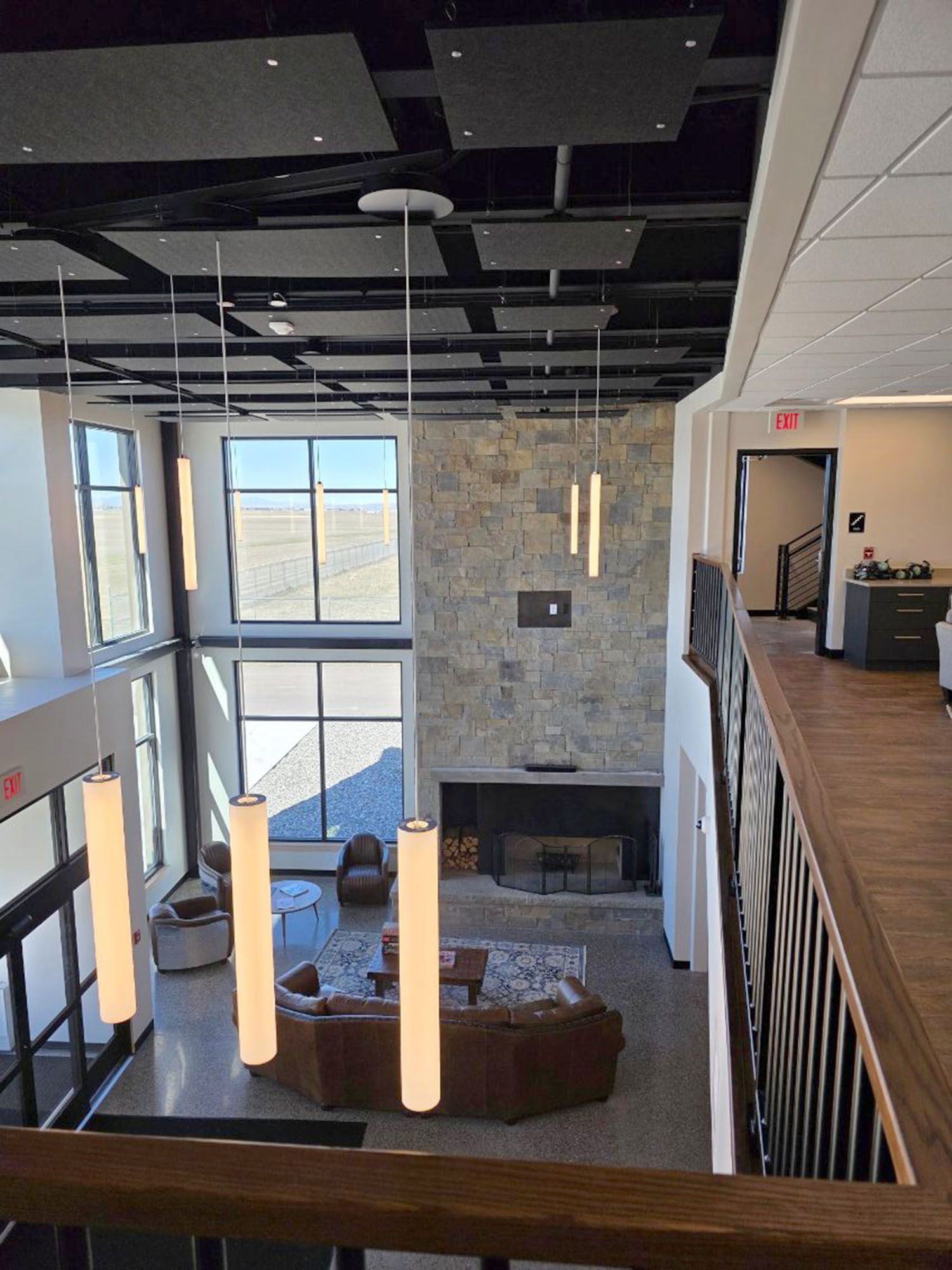 High-angle view of a modern two-story living area with a stone fireplace
