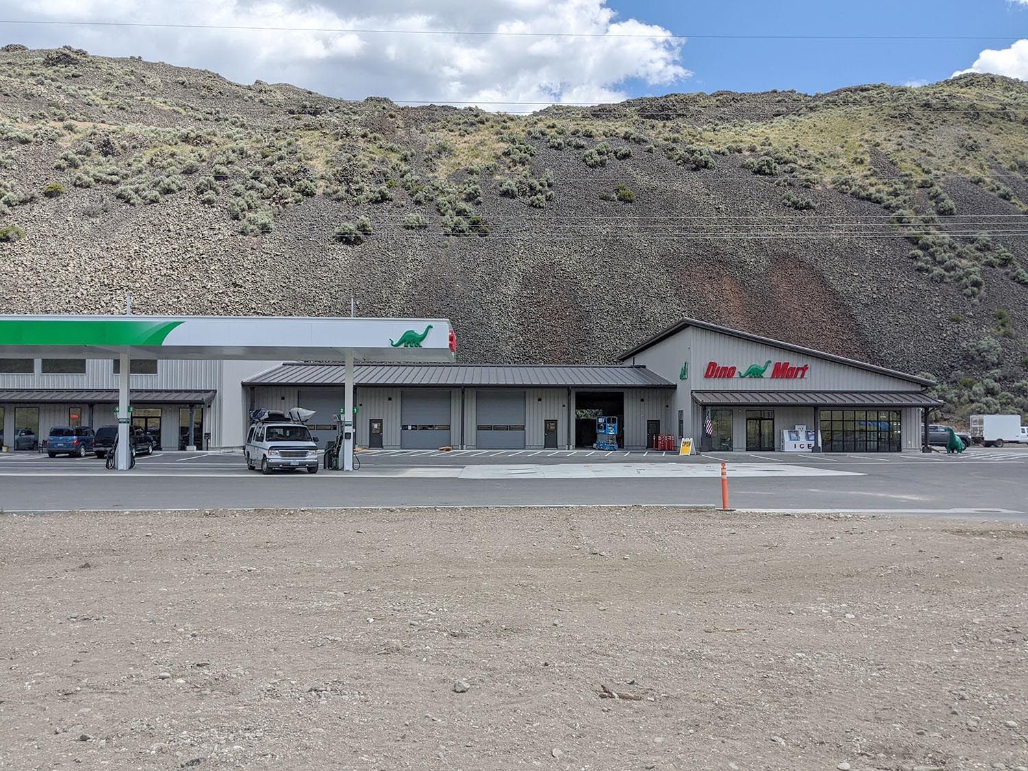 A gas station and convenience store with a large green and white canopy