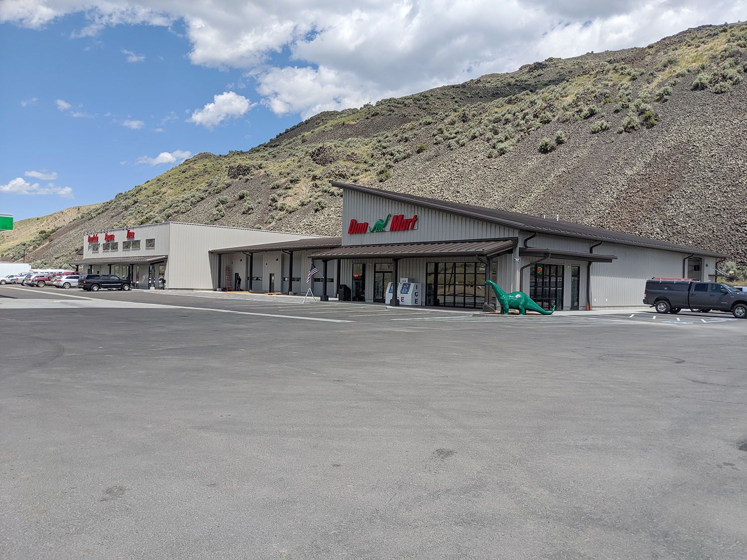 A light-colored retail shopping center with a sloped roof