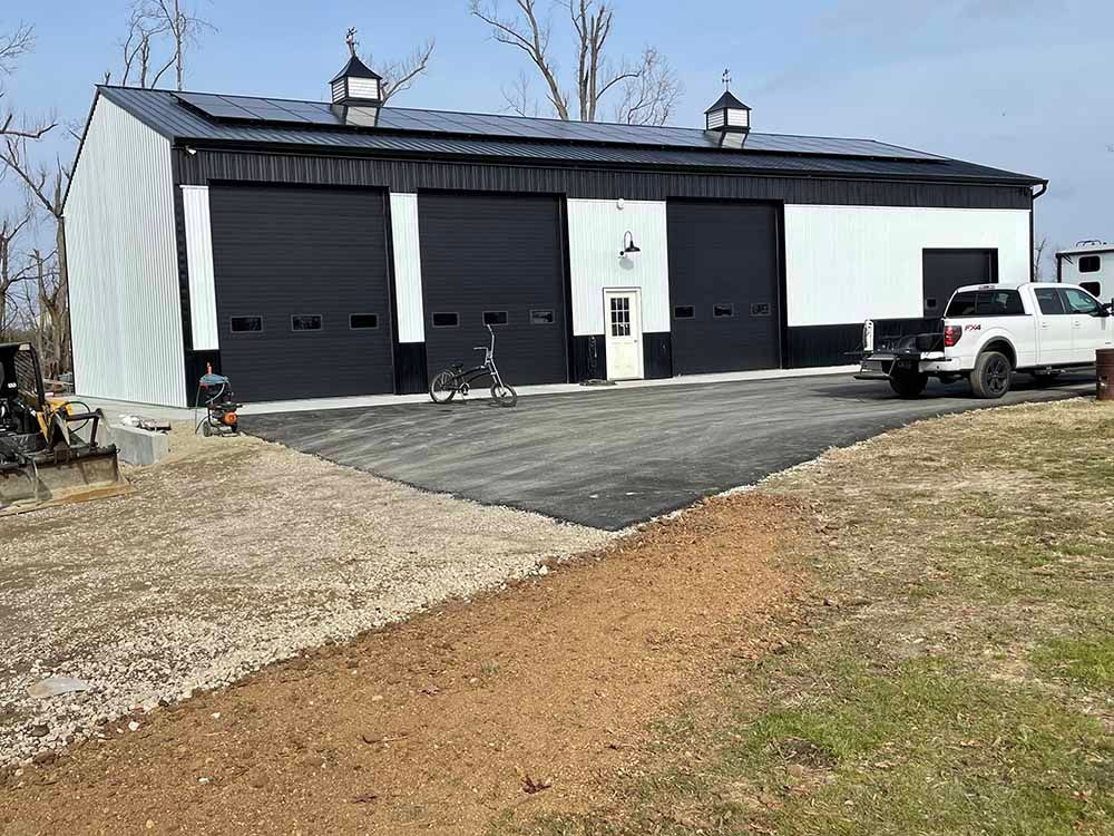 A white truck is parked in front of a large building.