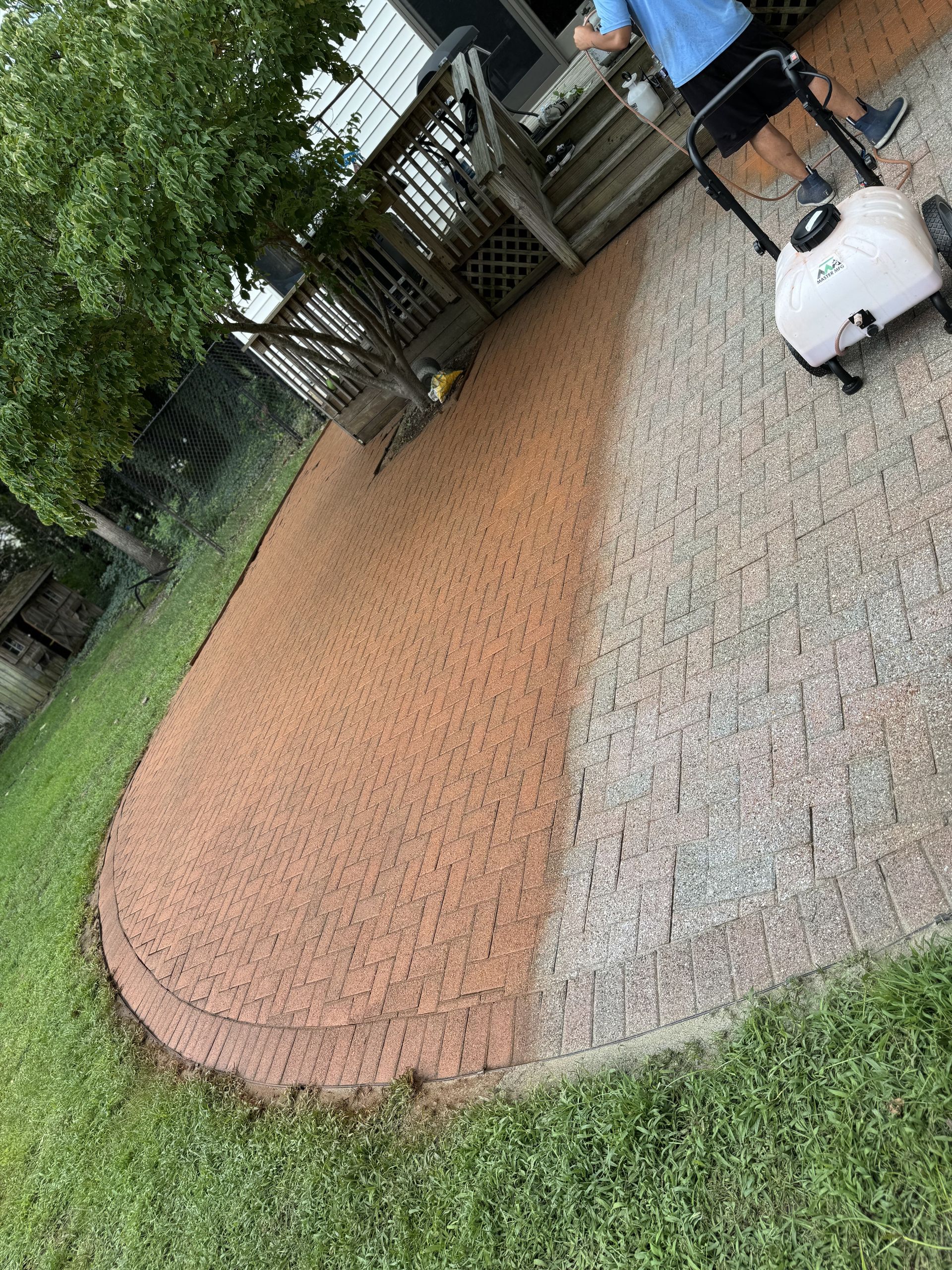 A man is cleaning a patio with a vacuum cleaner.
