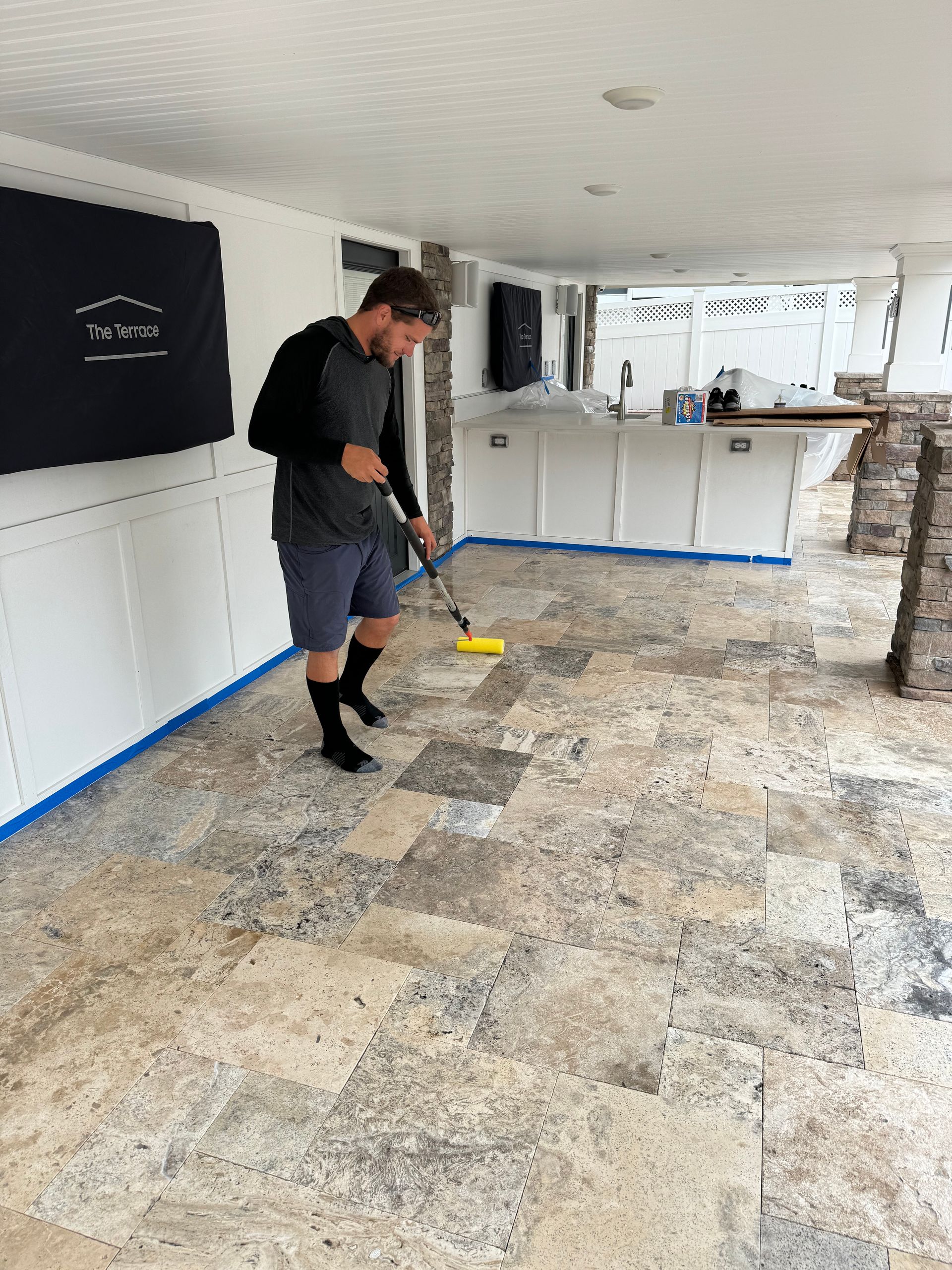 A man is cleaning a tiled floor with a mop.