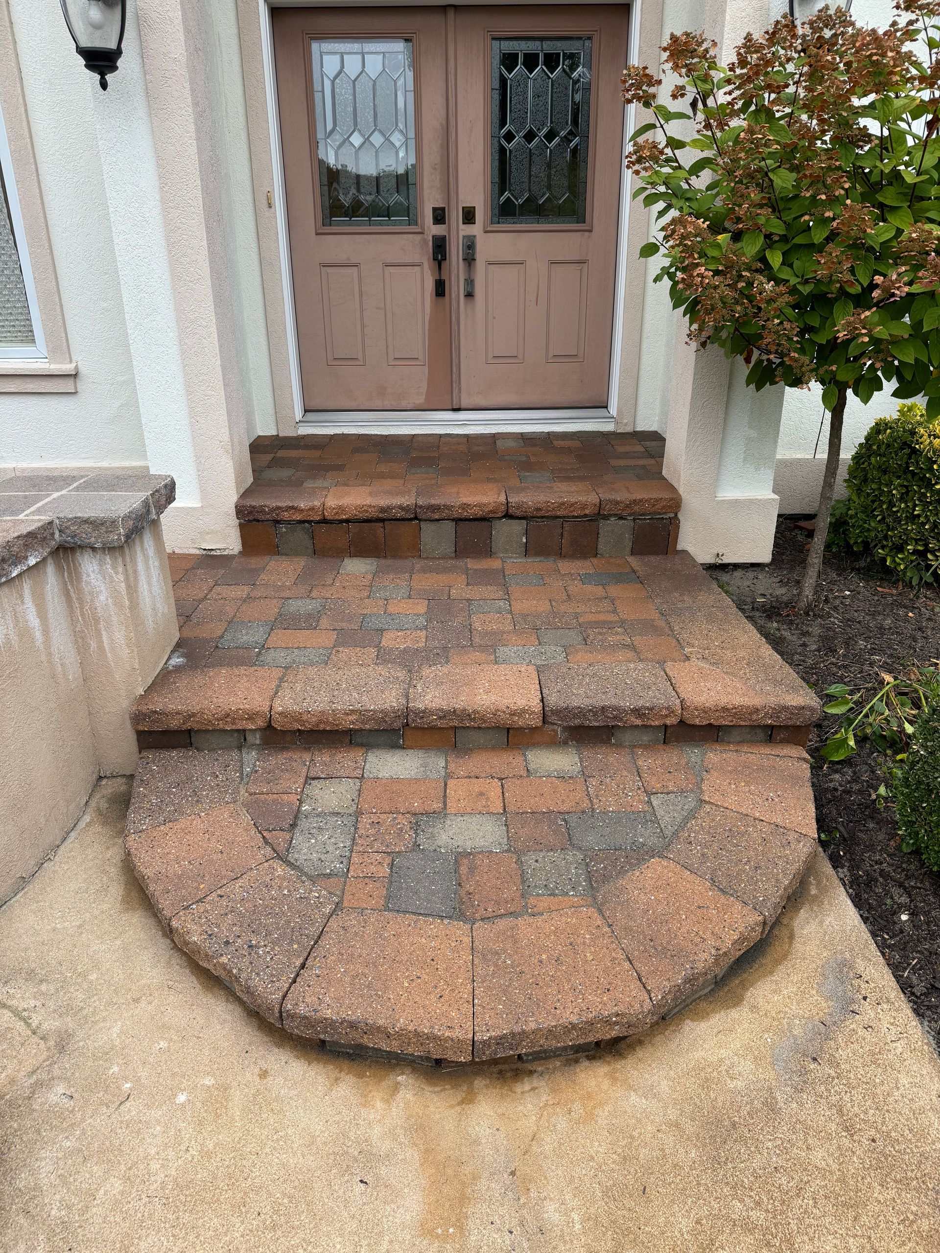 A brick walkway leading to the front door of a house.