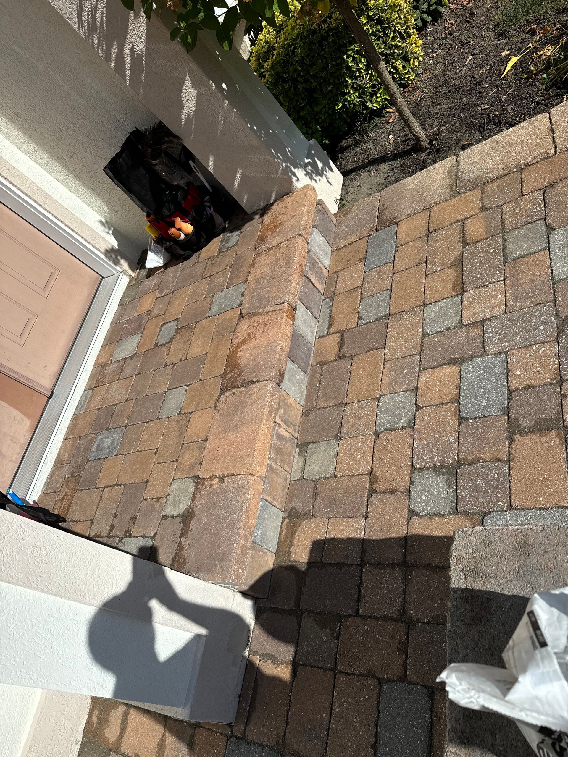 A brick walkway with a shadow of a person on it