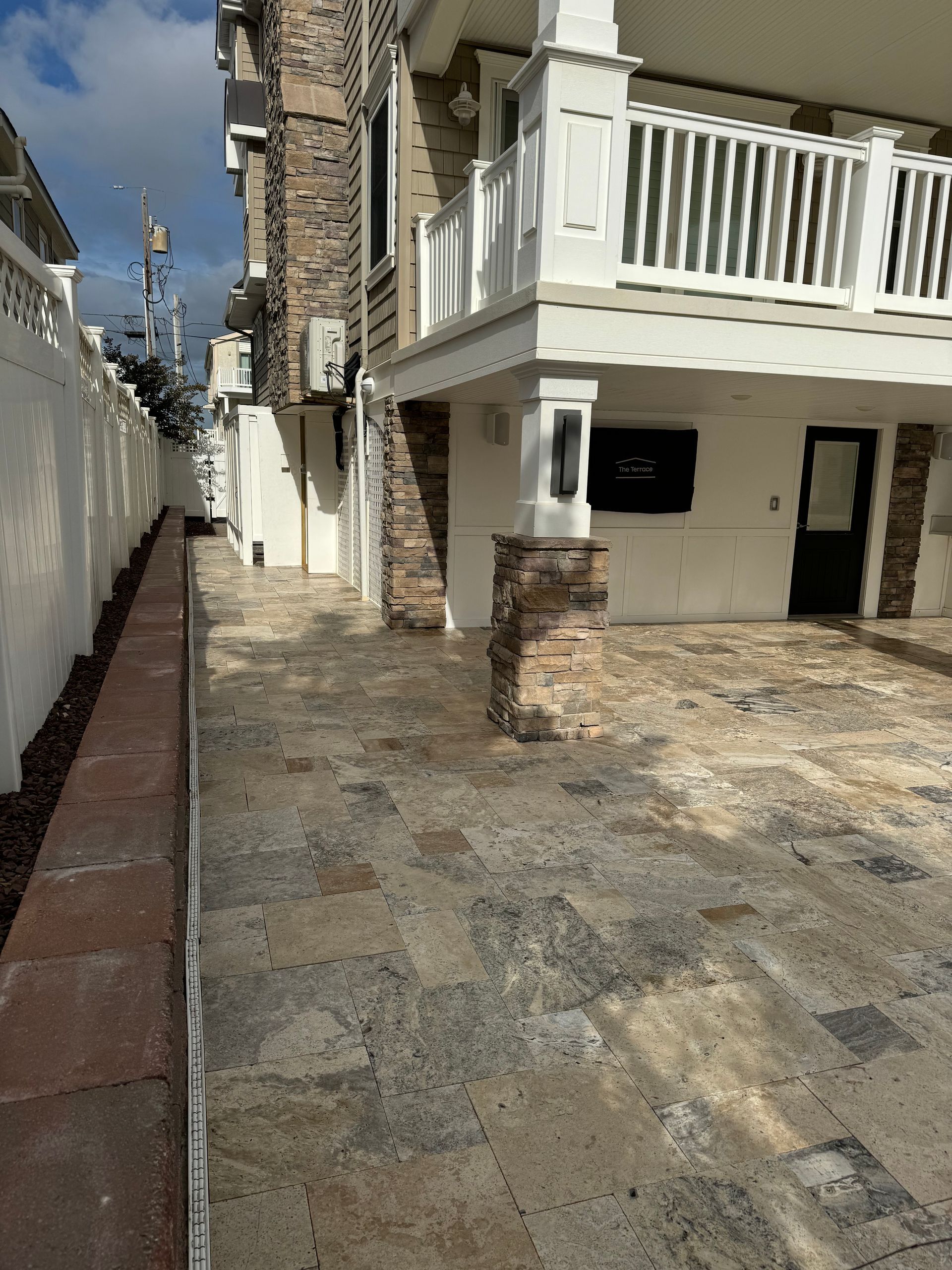 A sidewalk leading to a house with a balcony