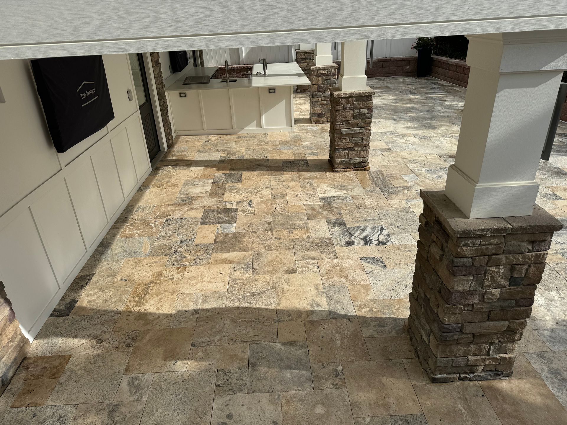 A patio with tile floors and brick pillars