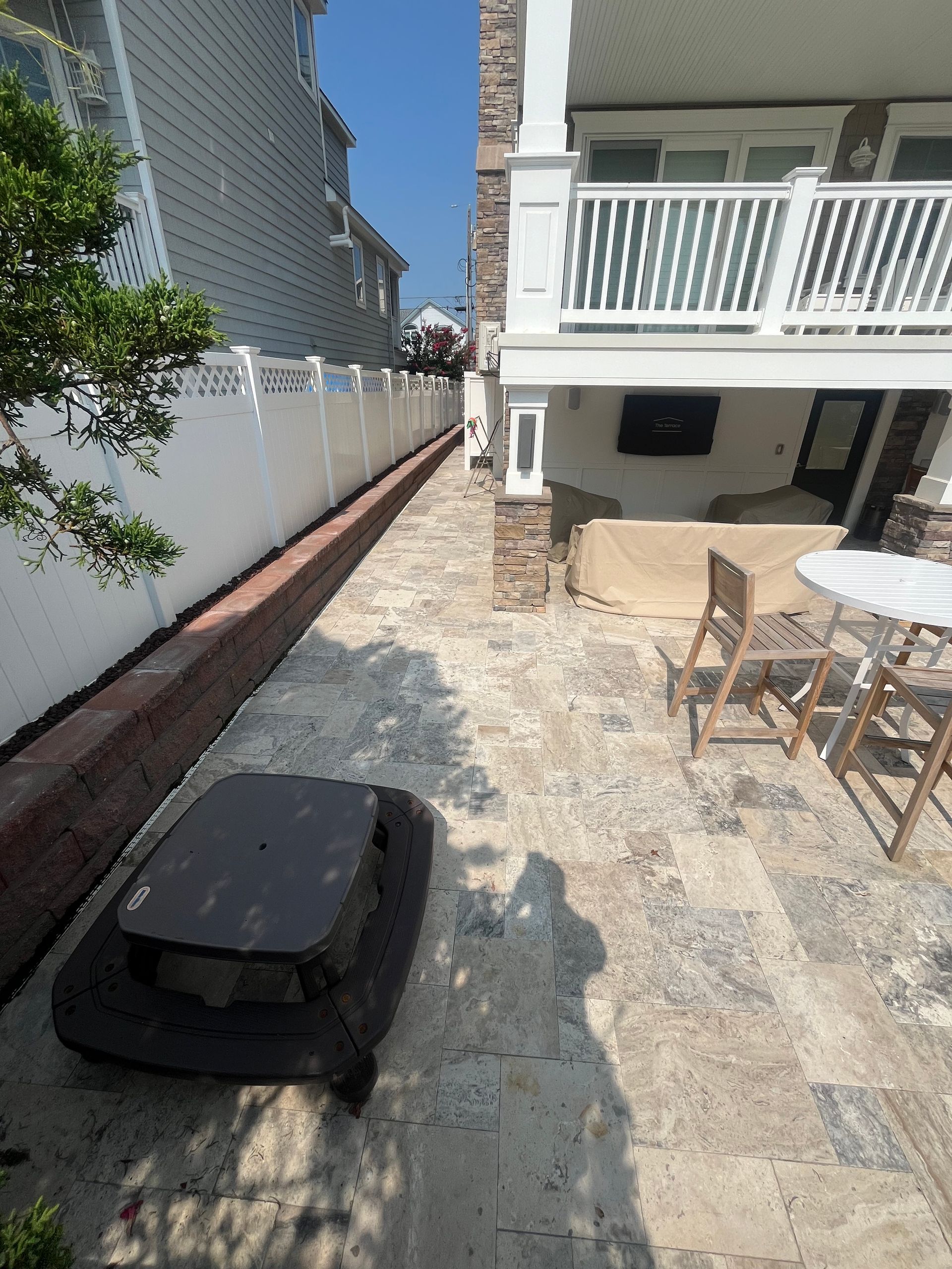 A patio with a table and chairs in front of a house.