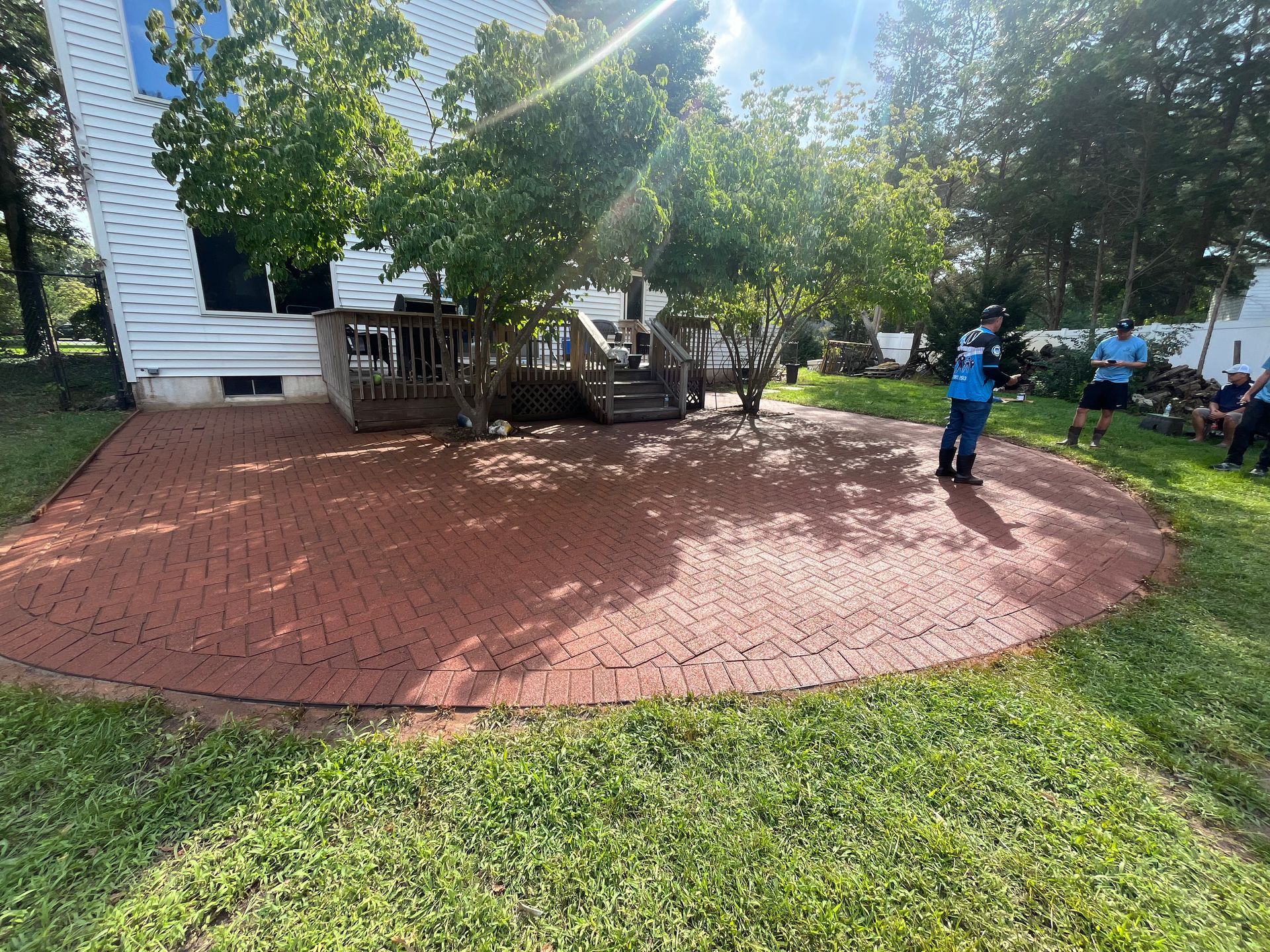 A group of people are standing in a circle in front of a house.