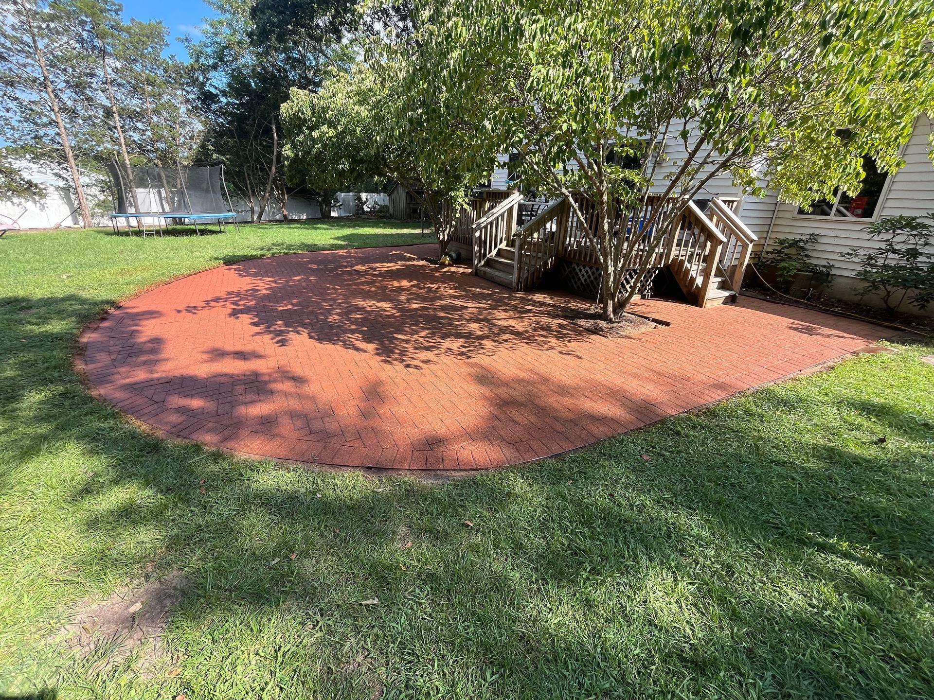 A circular area in the middle of a lush green field with a wooden bridge in the background.