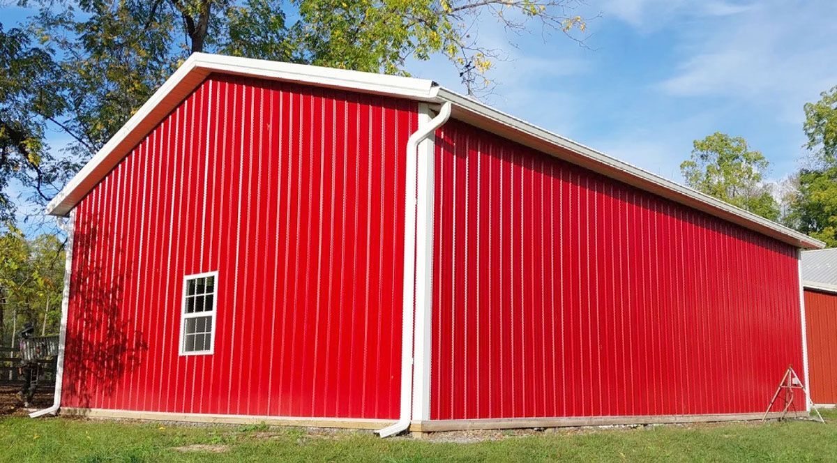 A large red barn with a white gutter