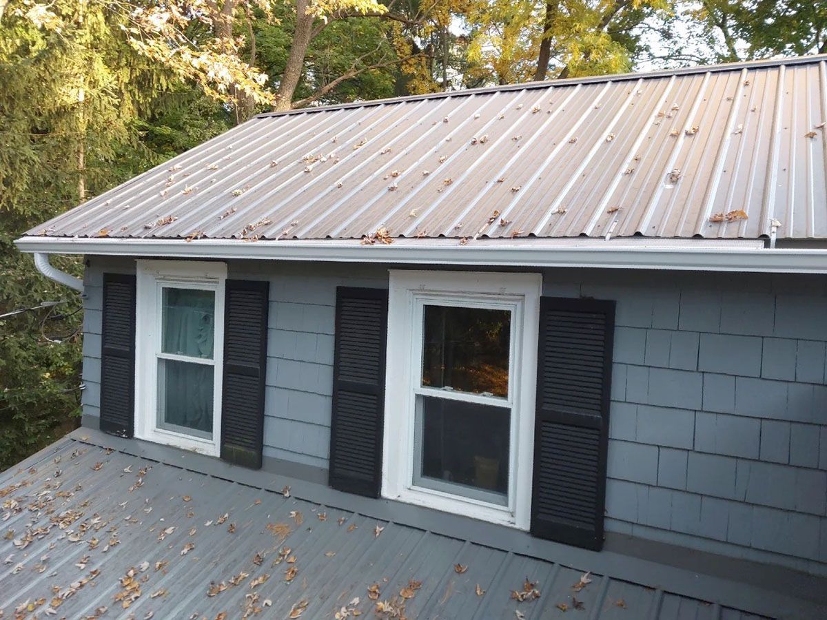 A house with a metal roof and white gutters