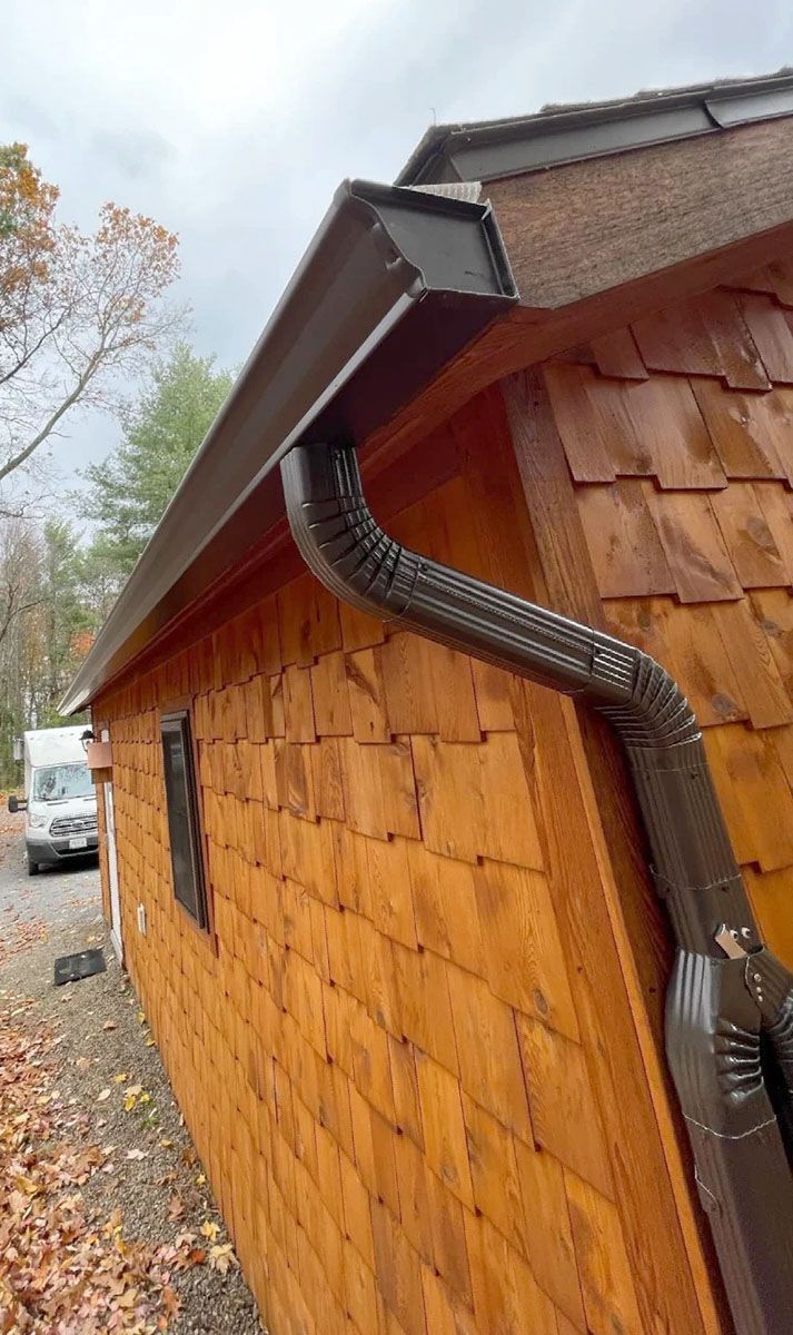 A close up of a gutter on the side of a house