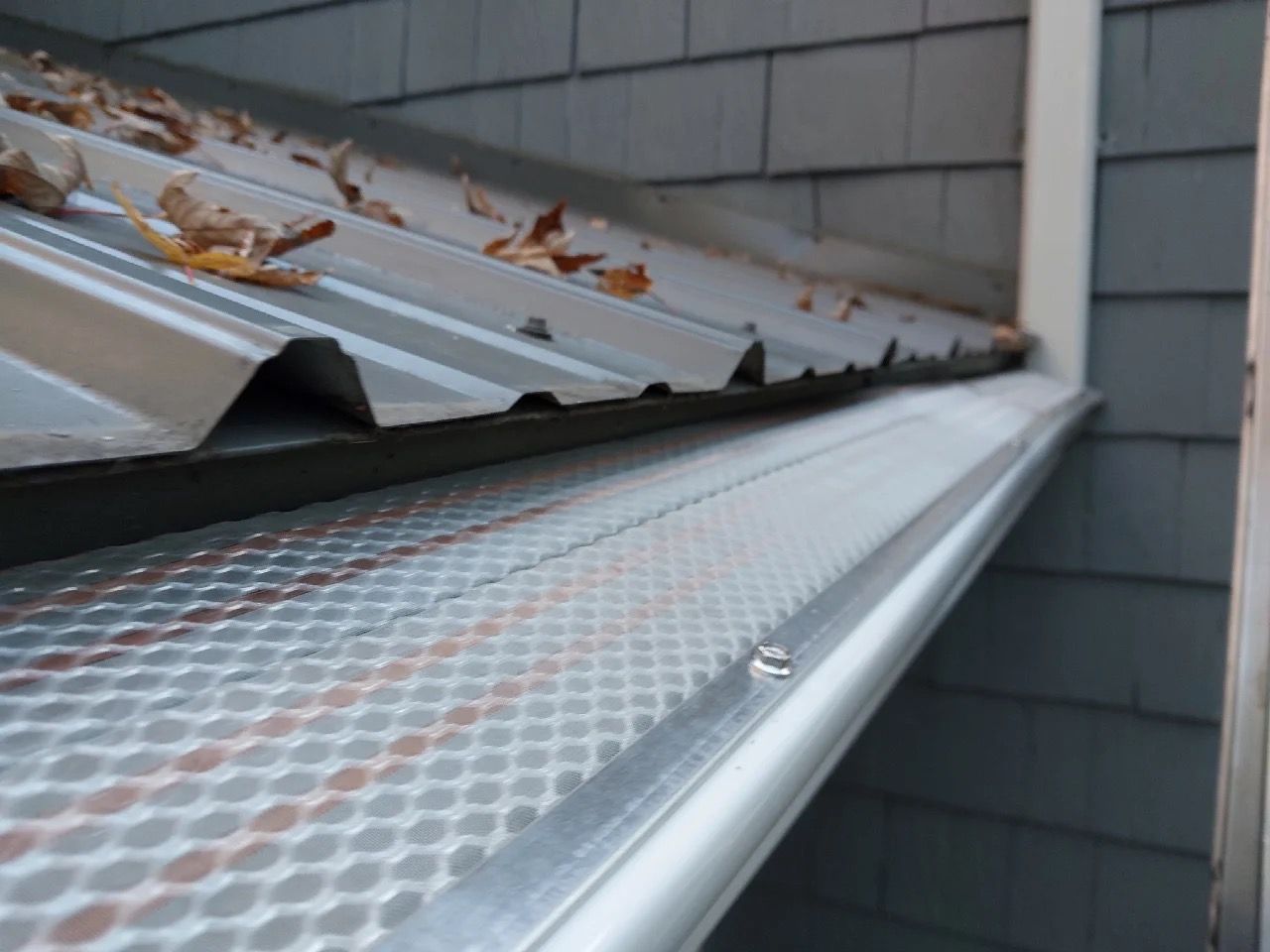 Long view of gutter with screen and plastic on top.