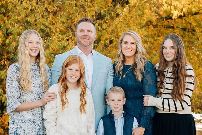 A family is posing for a picture in a park.