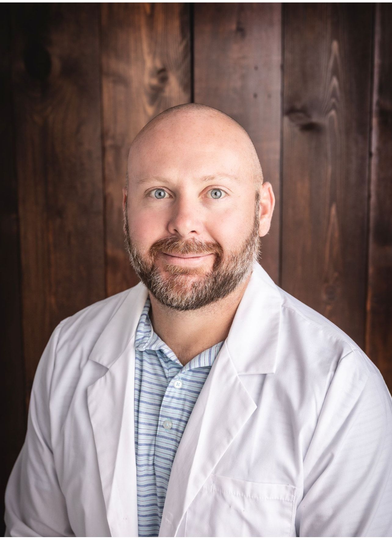 A bald man with a beard is smiling for the camera.
