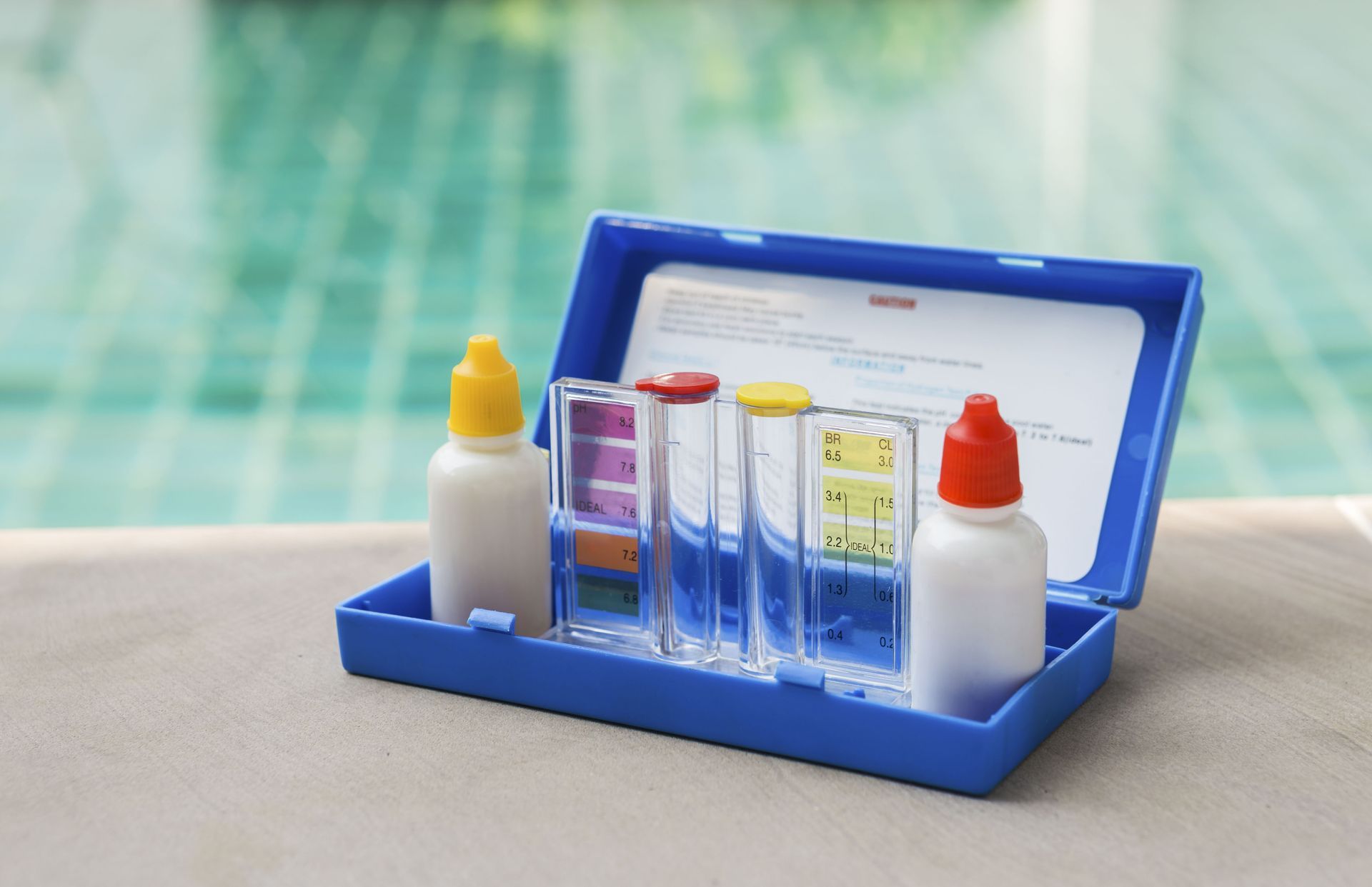 Blue pool water test kit with bottles and colored comparator windows.