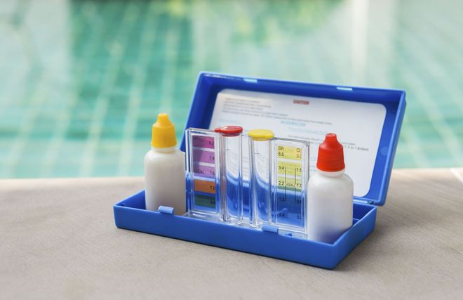 Blue pool water test kit with bottles and colored comparator windows.