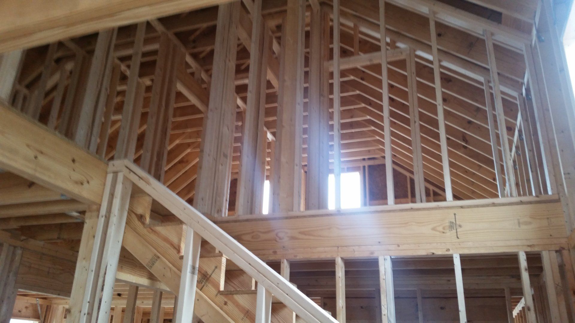 A house is being built with wooden beams and stairs