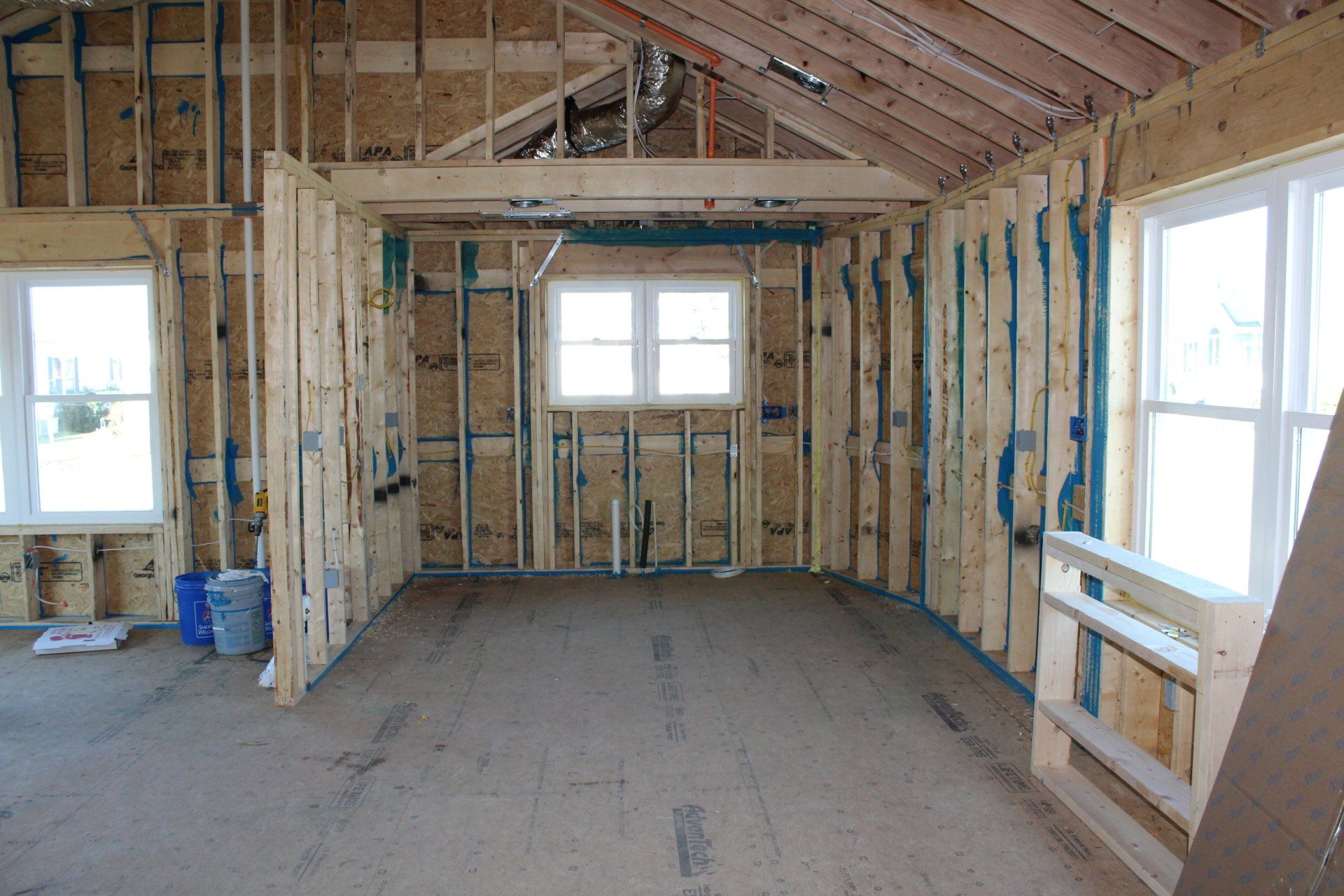 A room in a house under construction with a lot of windows