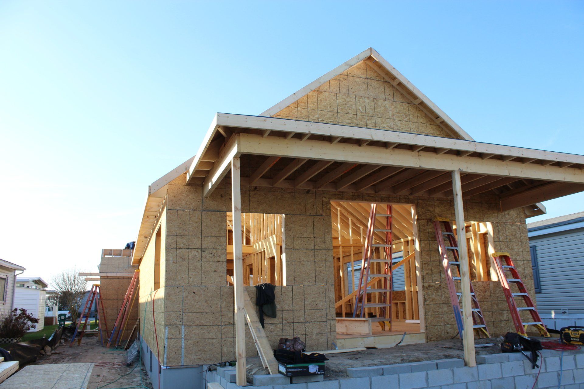A house is being built with a porch and a blue sky in the background